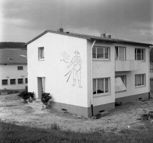 Wohnhaus mit Wandbild eines Säenden. Eckansicht