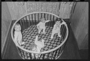 Vier Kleinkinder in einem runden Ställchen, 1960er Jahre. SW-Foto © Kurt Schwarz.