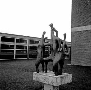 Emil-von-Behring-Gymnasium: Sieker Landstraße: Kunst am Bau: vorn Grünanlage mit Bronzeplastik "Das Gespräch" des Bildhauers Ferdinand Mathiszig: dahinter Schulgebäude