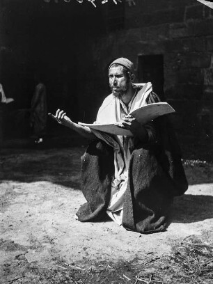 Betender Mann mit Koran als Modell : Kairo. Betender Mann mit Koran als Modell des Malers Emil Uhl, vor einem Gebäude sitzend