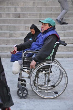 Barcelona - Behinderter im Rollstuhl bettelt : Vor der Kathedrale sitzt ein behinderter Mann in seinem Rollstuhl und bettelt Passanten an. Aufgenommen am 15. April 2012 in Barcelona