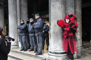 Karneval in Venedig : Rote Maske, Fotografin, Polizeibeamte. Aufgenommen am Rosenmontag, dem 20. Februar 2012 auf dem Markusplatz in Venedig