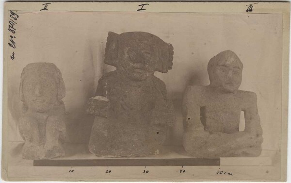 I Idole en lave d'anderite noire poreuse (Texcoco, Mex.) II Idole accroupie en lave d'anderite gris clair (cornblind). Hauteur env. 30 cm, largeur 15 cm (Mexique) III Figure assise, jambes croisées et bras croisés, en pierre brune. Hauteur : env. 35 cm, largeur : 22 cm.