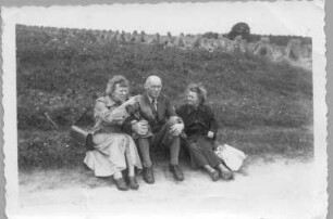 Etha Richter mit einem Ehepaar, an einem Feldrand sitzend