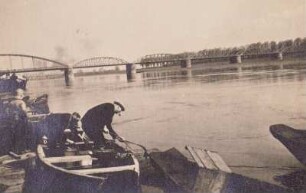 Torgau, Fischer in seinem Boot. Blick zur Elbbrücke