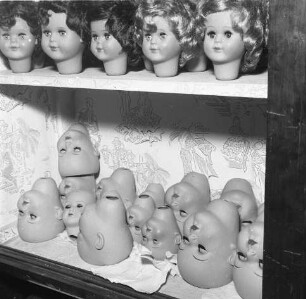 In einer Puppenklinik. Regal mit verschiedenen Puppenköpfen