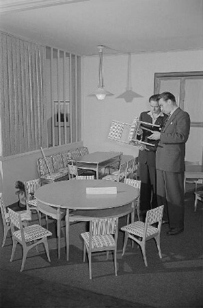 Zwei Männer begutachten auf der Leipziger Herbstmesse 1955 ausgestellte Kindermöbel