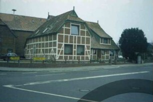Poststraße 2: traufständiges Fachwerkhaus: rechts Straßenfront mit Eingangstür und Gaube: links Querbau, Giebelseite und Traufseite: links dahinter Haus Steinern 1a: an Straße Hinweisschilder nach Mölln und Trittau, im Vordergrund Einmündung von Bahnhofstraße