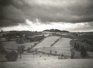 Špičák (deutsch Sattelberg, auch Schönwalder Spitzberg). Tschechien. Von der sächsischen Seite gesehen, mit Regenwolken