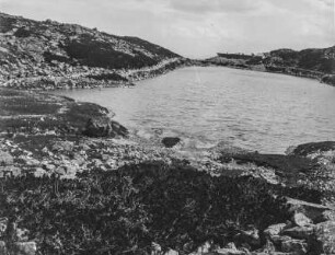 Am See : Blick über eine See mit Geröll am Ufer