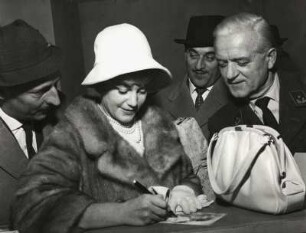 [Internationale Filmfestspiele, Maria Schell schreibt Autogramme, im Hintergrund Artur Brauner]