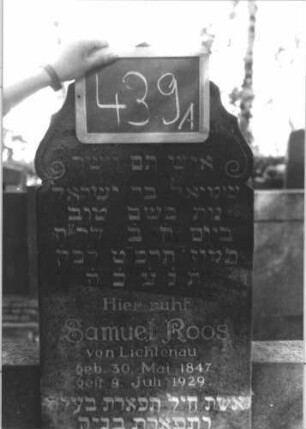Grabstein 439 (Index: 100111737) Material: Granit Zustand: gut Maße HxBxT: 176x94x12 cm Beschreibung: Stele mit halbhohen Seitenflügeln, Sockel, geschwungen eingezogener giebelartiger Abschluß Symbolik: Voluten Besonderheit: Doppelgrab für Eheleute: Grabstein 439A
