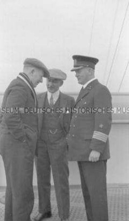 Kapitän Leopold Ziegenbein mit zwei Passagieren auf der Kommandobrücke des Hochseepassagierdampfers "Bremen"