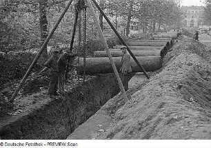 Dresden. Rohrleitungsarbeiten mit Flaschenzug an Holzvierbock