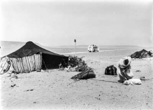 Zelt eines Berbers : Berber mit seinem Hund und Hühnern vor seinem Zelt, hinter ihnen Autostraße von Nalut nach Ghadames.