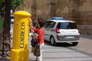 Cordoba - Japanische Touristen stehen an einem Briefkasten