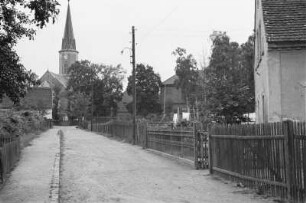 Straße : Blick entlang einer schmalen Straße in Richtung einer Kirche