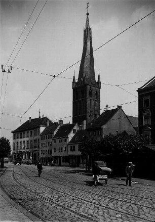 Düsseldorf (Nordrhein-Westfalen). Straßenszene. Rathausufer. In der Bildmitte der Turm der Pfarrkirche St. Lambertus.