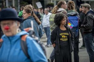 linke Demonstranten protestieren am Hamburger Hauptbahnhof gegen eine Neonazi-Demo, die kurz zuvor gerichtlich verboten wurde. hier: Demonstrantin mit T-Shirt: Refugees Welcome