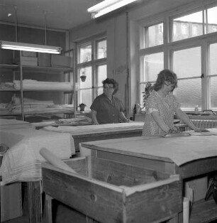 Roßwein, Bahndammstraße. VEB Maßmieder- und Wäschefabrik (vormals Karl Spranger Maßkorsettfabrik). Vorgänge in der Produktion. Zuschnitt. Teilansicht des Produktionsraumes