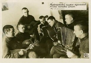Musikalischer Zirkel der Kursteilnehmer (sieben musizierende Soldaten) mit Gitarren und Harmonium in der Schule des 10. Regiments in Kasernenzimmer