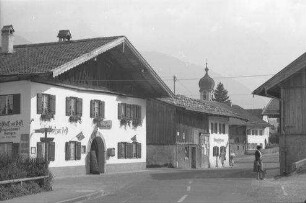 Krün: Dorfstraße mit Kirchturm [mit Gasthof zur Post]