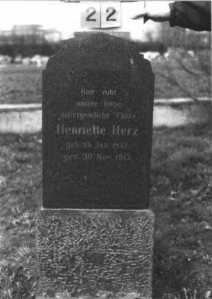 Grabstein 22 (Index: 99808551) Material: polierter Granit auf Granit Zustand: sehr gut Maße HxBxT: 129x53x33 cm Beschreibung: Stele auf Sockel, mehrfach eingezogener, giebelartiger Abschluß Symbolik: gemusterter Rand: Grabstein 22
