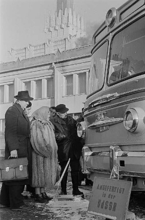 Messebesucher betrachten einen in der UdSSR hergestellten Bus (Mockba). Im Hintergrund der sowjetische Pavillon