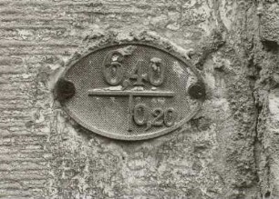 Hydranten- (oder Schieber-) Hinweissschild, Gußeisen, um 1910, am Portal des Wohnhauses des Dreiseithofes