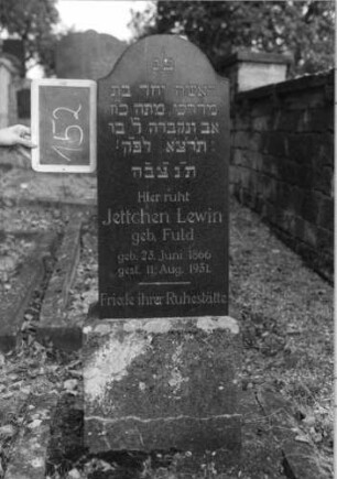 Grabstein 152 (Index: 100080417) Material: Granit Zustand: gut Maße HxBxT: 122x37x17 cm Beschreibung: Stele, Sockel, schräg eingezogener Rundbogenabschluß: Grabstein 152