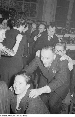 Gäste einer Betriebsweihnachtsfeier beim Tanzen einer Polonaise