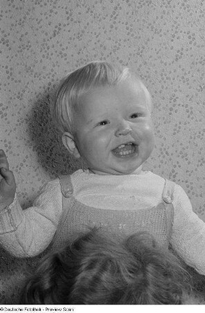 Portrait eines Kleinkindes auf den Schultern einer erwachsenen Person