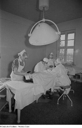 Ein Arzt und drei Krankenschwestern bei einer Operation im Dr.-Georg-Sacke-Heim