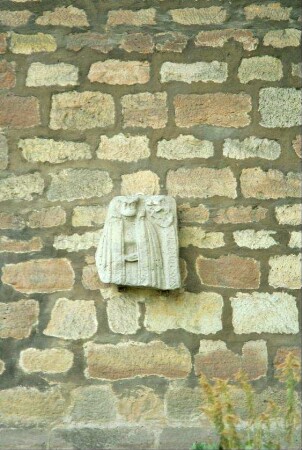 kleine Steinplatte mit Relief an einer Bruchsteinwand