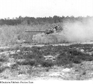 Deutschland . Nationale Volksarmee - Landstreitkräfte. Kampfpanzer mit aufgesessenen Schützen in Fahrt in offenem Gelände