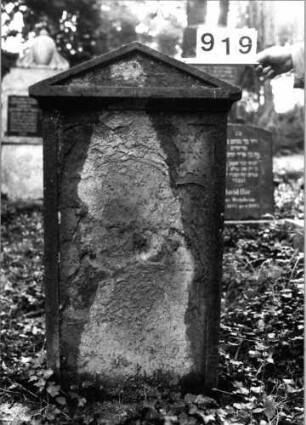 Grabstein 919 (Index: 99802577) Material: Sandstein Zustand: heb. Text verwitt/nur einzelne Buchstaben Maße HxBxT: 123x60x20 cm Beschreibung: Stele mit verdachtem Giebel und profiliertem Rand: Grabstein 919