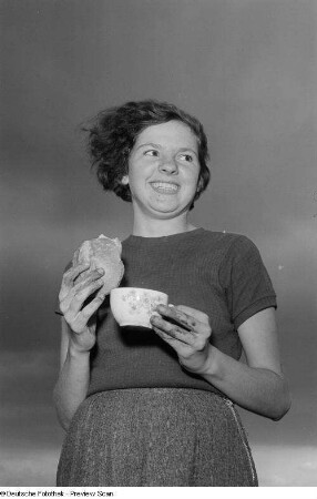 Porträt Inge Seeligs mit einem belegten Brötchen und einer Tasse in den Händen