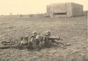 Drei Soldaten um ein Maschinengewehr