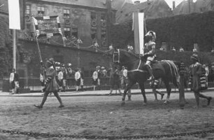 Turnierspiele 1936 : Dresden, Stallhof, Turnierspiele. Aufritt zum Turnier, Ritter im Harnisch mit Spießknecht mit Wappenstandarte