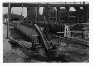 Industrie-Kraftwerk. Baustelle einer Eisenbahnbrücke (Grubenbahn über Werkgleis), im Hintergrund aufgeständerte alte Trasse der Grubenbahn und Werkanlagen mit Kühltürmen : Lauta (Niederlausitz). Industrie-Kraftwerk. Baustelle einer Eisenbahnbrücke (Grubenbahn über Werkgleis), im Hintergrund aufgeständerte alte Trasse der Grubenbahn und Werkanlagen mit Kühltürmen
