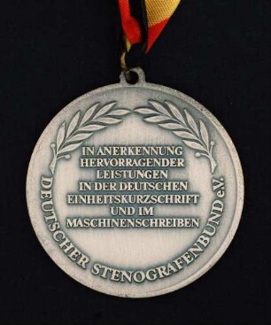 Silbermedaille Deutsche Meisterschaften in Kurzschrift und Maschinenschreiben in Goslar 1991 am schwarz-rot-goldenen Band : Sammlung Deutscher Stenografenbund. Silbermedaille Deutsche Meisterschaften in Kurzschrift und Maschinenschreiben in Goslar 1991 am schwarz-rot-goldenen Band. Messing, versilbert; Durchmesser 50 mm, Gewicht 37,5 g (1991; Deschler & Sohn, München). Dresden: SLUB R c 0558