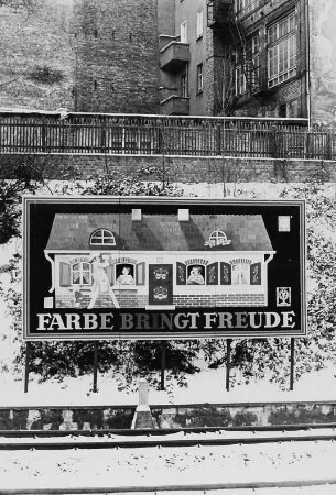 Plakat "Farbe bringt Freude" an Bahngleisen