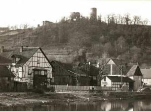 Bad Karlshafen-Helmarshausen (Kr. Kassel). Helmarshausen, Häuser an der Diemel, dahinter Ruine Kruckenburg