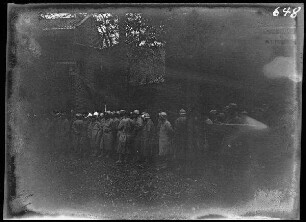 bei Neuville (=Neuville-Saint-Vaast, Dep. Pas-de-Calais, Frankreich): Soldaten (französische Kriegsgefangene?) am Wegesrand vor einem Backsteingebäude