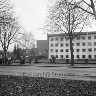 Alfred-Rust-Realschule: Wulfsdorfer Weg: Straßenfront: Schüler an der Bushaltestelle