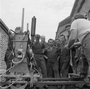 Blankenburg (Harz). Forschungs- und Entwicklungswerk für Verkehrswesen Blankenburg. Beratung am Gerät zur lehrschienenlosen Gleisjochverlegung (teilweise im Bild) mit der Brigade Kärner
