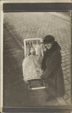 [Eine Mutter mit einem Kinderwagen]