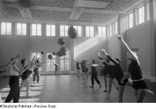 Sportlerinnen während einer Übung mit einem Medizinball in einer Sporthalle der Deutschen Hochschule für Körperkultur in Leipzig