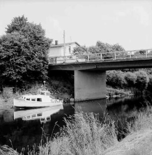 Groß Barnitz: Trave: Brücke zwischen Groß Barnitz und Lokfeld: vorn links Motorboot: hinten Bäume und Haus