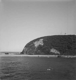 Bluff : Blick auf eine bewachsene Sanddüne neben der Hafenausfahrt, darauf ein Leuchtturm